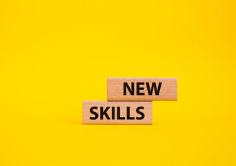New skills symbol. Wooden blocks with words New skills. Beautiful yellow background. Business and...