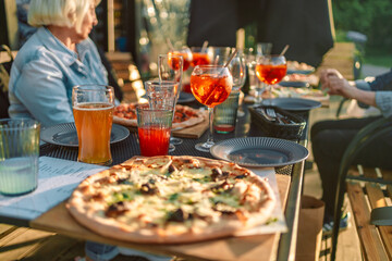 Served banquet table with fresh pizza food, cocktail drinks at street cafe at sunrise time