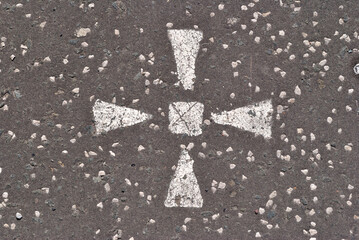 White Painted Stylized Cross on Grey Tarmac Road Surface