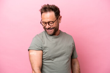 Middle age man wearing a band aids isolated on pink background with happy expression