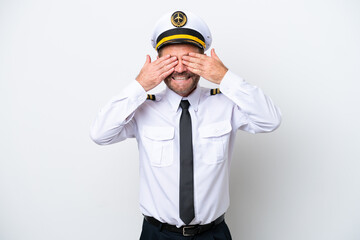 Airplane middle age pilot isolated on white background covering eyes by hands