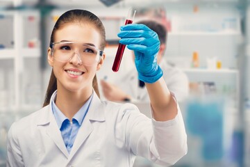 Couple of satisfied diagnostic laboratory scientist against copy space workplace background. Medical specialist in lab c holding test tube.