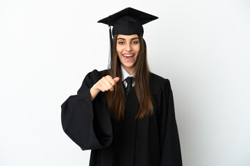 Young university graduate isolated on white background surprised and pointing front