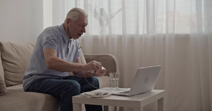 Pensioner showing pill box to online doctor