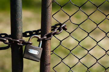 in the photo, a metal fence, a mesh chain and a lock