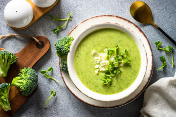Broccoli cream soup with parmesan. Healthy green soup, vegan dish. Top view at stone table.