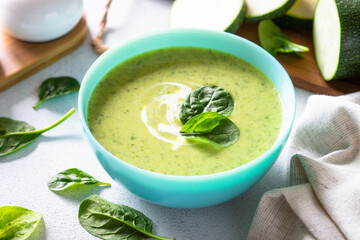 Green soup. Zucchini and spinach cream soup at light table. Healthy vegan dish. Close up.