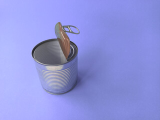 One shiny clean metal tin can stands in a row on a purple background. The concept of ecology, waste recycling and environmental conservation