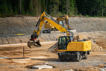 Two excavators at work - prepare ground for concrete foundations on the site of a new building