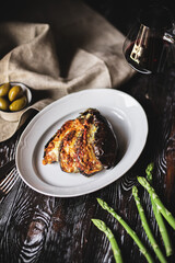 Food photography. Baked eggplant with olives and cheese on a dark wooden background