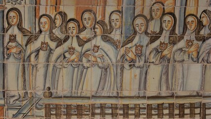 Tile mural depicting Mercedarian nuns wearing the coat of arms of their order on their habit praying in the choir, at Monasterio de la Encarnación monastery cloister, Osuna, Spain