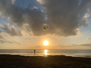 Kitesurfer walking his kite into sunset