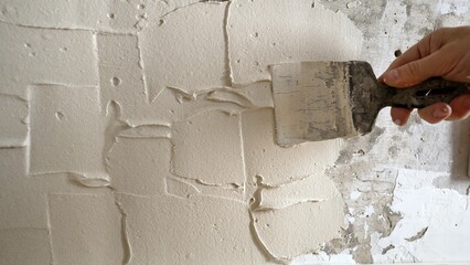 The tile is applying adhesive to the kitchen wall. The process of applying plaster adhesive for...