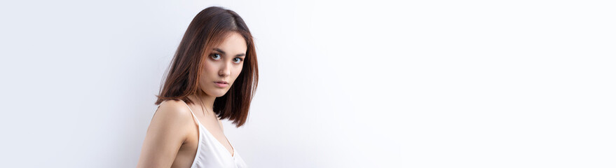 Beautiful smiling woman with clean skin, natural make-up and white teeth on a gray background