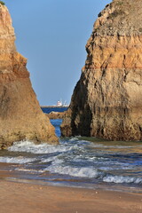 Praia Tres Castelos Beach-seastacks framed Farol Praia Rocha Lighthouse. Portimao-Portugal-286