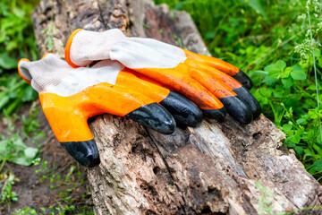 Wet rubberized gloves on a wooden stump.