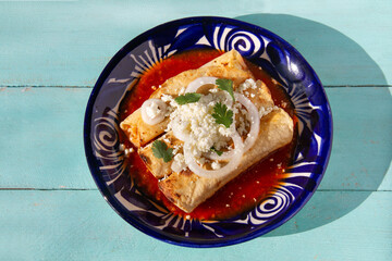 Fried potato tacos called flautas with red sauce and cheese. Mexican food
