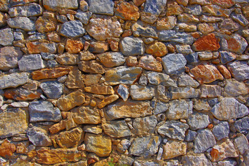 Old stone wall built from different stones and cement.