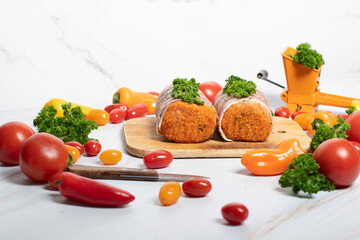 minced meat sausages in bacon with green parsley and fresh vegetables, cherry 