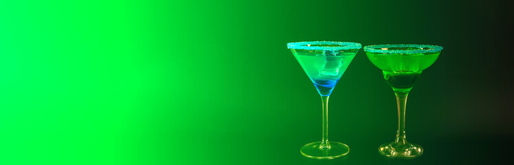 Delicious alcoholic cocktails with ice cubes in green and blue colours