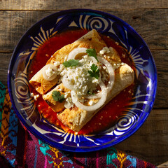 Fried potato tacos called flautas with red sauce and cheese. Mexican food