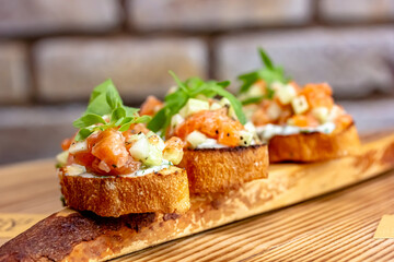 dry aged smoked salmon on the slices of bread and cream cheese sandwiches with cherry tomatoes and rocket salad