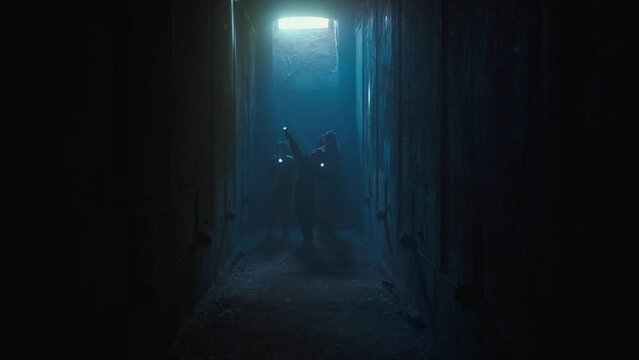Children with flashlights walking through dark tunnels