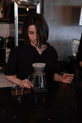 charming brunette woman barista making filter coffee in coffee shop. brewing coffee in cafe