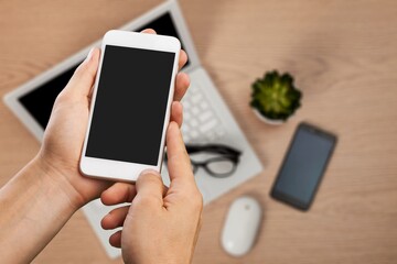 Man holding a smartphone with app on the screen on Office workplace.