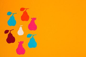 colorful paper pears arranged in a circle on the left side of the yellow background, creative summer design, copy space, colorful vitamin background, minimal concept