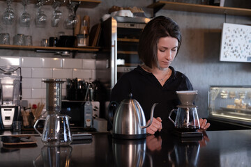 charming brunette woman barista making filter coffee in coffee shop. brewing coffee in cafe