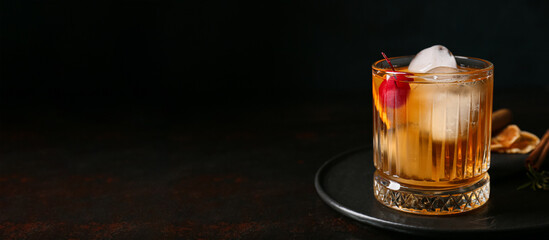 Glass of delicious Old Fashioned cocktail on black background with space for text
