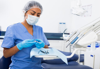 Nurse prepares instruments before the patient is seen by the dentist