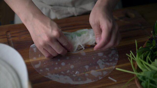 asian women hands wrapping Vietnamese summer roll