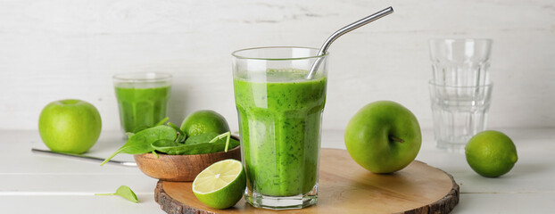 Glass of tasty green smoothie and ingredients on table