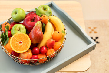 Tray with fruit basket on wooden table, closeup
