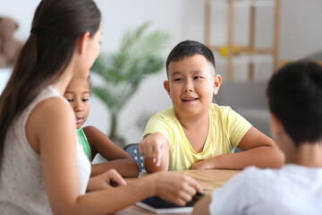 Little Asian boy having literature lesson in classroom