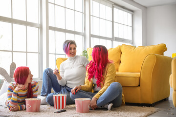 Beautiful women eating popcorn at home