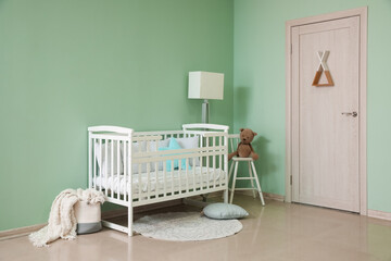 Interior of stylish nursery with baby crib, lamp and chair