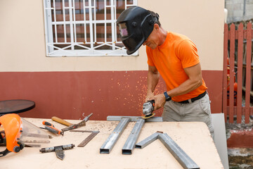 A man in his yard is engaged in locksmith work. Hobby, in a home workshop.