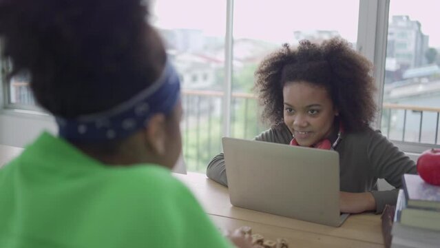 Classroom With Diverse Learners Doing Activities Together.Two Black Students Talking In Class. American Students Are Using A Laptop During Classes. In Diverse Education Concept.