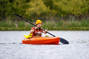 Young attractive girl paddling in canoe still water