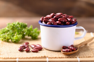 Red kidney beans in bowl on wooden table, Food ingredients