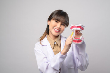 Young female dentist smiling over white background studio