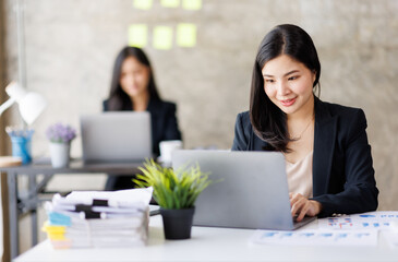 Portrait of Asian office employee businesswoman working in an office, doing planning analyzing the financial report, business plan investment, finance analysis concept. Office background.
