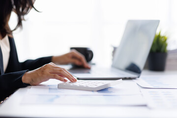 businesswoman Using calculator and tablet working at office with document on her desk, doing planning analyzing the financial report, business plan investment, finance analysis concept. 