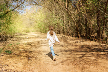 Little pretty girl on walk in sunny spring park. Fairy forest. High quality photo