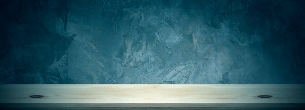 An empty wooden table and concrete wall background can be used to display or montage your products.