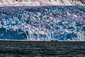 2022-05-10 ZODIAK CRUISE NEAR A GLACIER WITH TWO BOATS SHOWING SCALE NEAR SVALBARD NORWAY IN THE ARCTIC