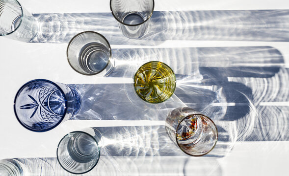 Glasses on table top casting textured shadows with split light